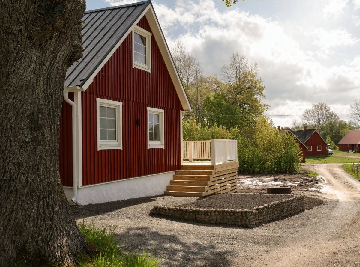 Husgavel med nybyggd trätrappa och stenmur