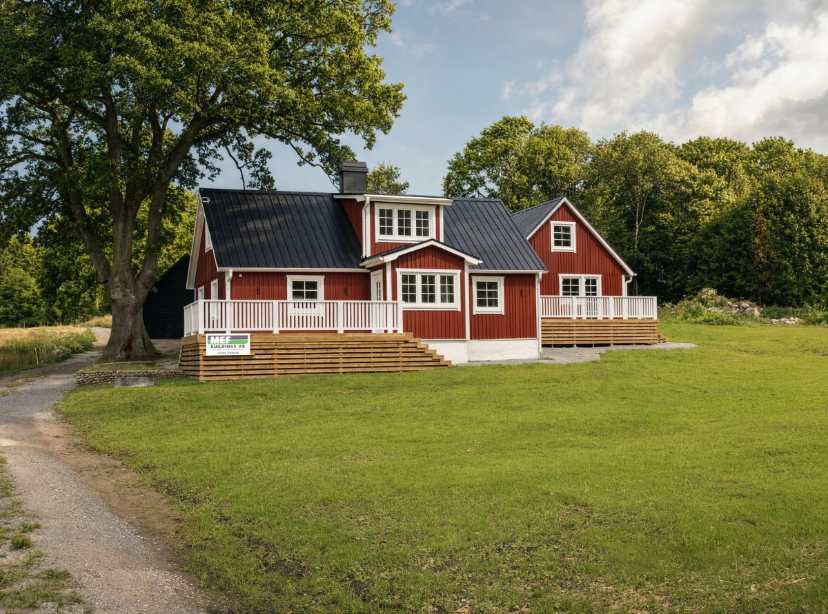 Rött hus med vit veranda och träaltan
